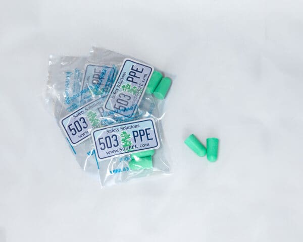 a small pile of 503 PPE Foam Formable Earplugs in their individually wrapped plastic packaging with logo sits on a white background.